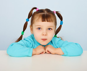 Image showing Little girl sitting at desk