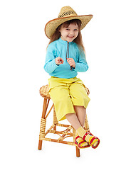 Image showing Little girl in straw hat sitting on wooden chair