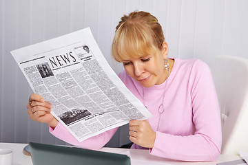 Image showing Woman reading newspaper - bad news