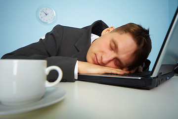 Image showing Tired man sleeping on a notebook