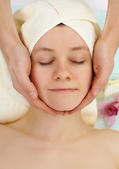 Image showing Young woman doing facial in beauty salon