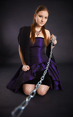 Image showing Young beautiful girl pulls out a chain leash