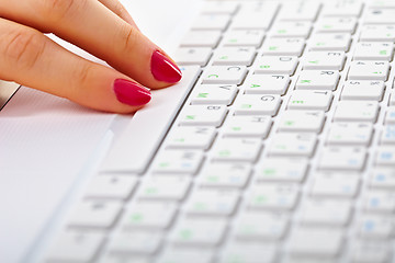 Image showing Female fingers on white laptop keyboard