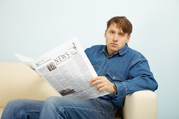 Image showing Man disappointed with news from newspaper