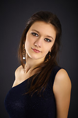 Image showing Portrait of a beautiful young woman in evening dress on black ba