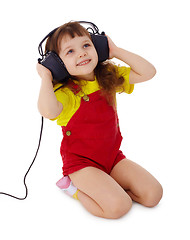 Image showing Little girl listens to music