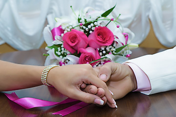 Image showing Hands of the newlyweds and bridal bouquet