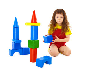 Image showing Child builds a toy castle on floor