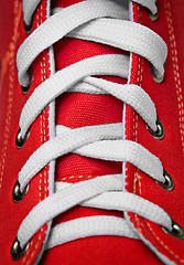 Image showing Red old-fashioned gym shoe - lacing