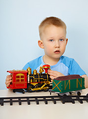 Image showing Little boy playing with a toy locomotive