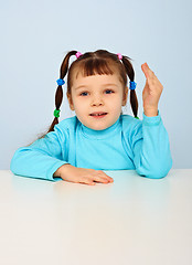 Image showing Little girl sitting at school desk