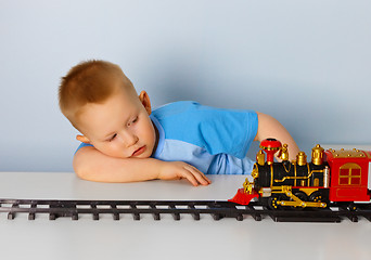 Image showing Little boy playing with a toy locomotive