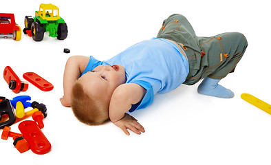 Image showing Child fooling on the floor among the toys