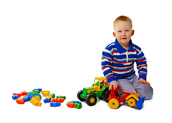 Image showing Boy sits on white background with toys