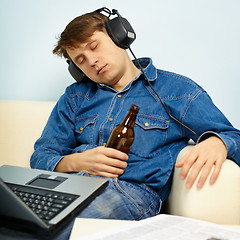 Image showing Man fell asleep at home on couch with a beer