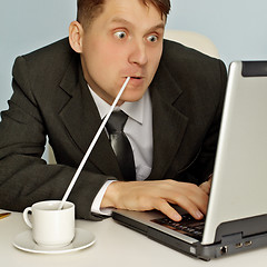 Image showing Funny businessman drinking coffee and working