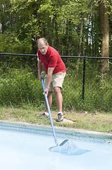 Image showing homeowner cleaning swimming pool