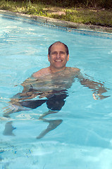 Image showing handsome smiling middle age man swimming in pool