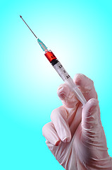 Image showing Hand holding a syringe