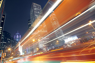 Image showing traffic light trails in the street by modern building