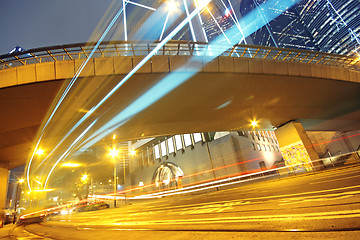 Image showing traffic light trails in the street by modern building