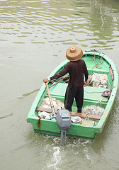 Image showing man on sampan boat with outboard motor 