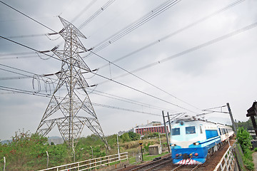 Image showing passenger trains in motion and power tower on background 
