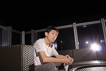 Image showing Man sit on a bench while relaxing at a pub. 