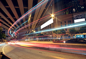 Image showing blurred bus light trails in downtown night-scape 