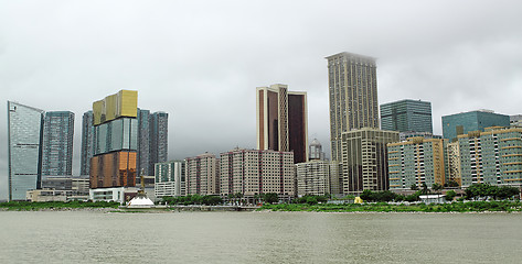 Image showing Macau cityscape with famous casino skyscraper under cloudy sky. 