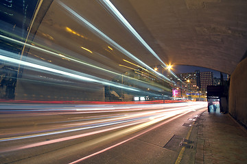 Image showing blurred bus light trails in downtown night-scape 