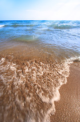 Image showing Beach pebbles under clear water with waves