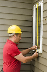 Image showing carpenter measuring window repair
