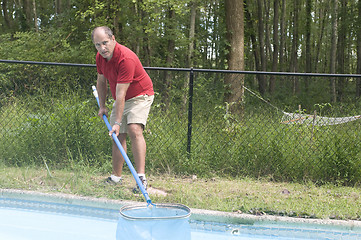 Image showing homeowner cleaning swimming pool