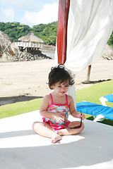 Image showing baby girl in sunglasses on the beach playing getting prepared fo