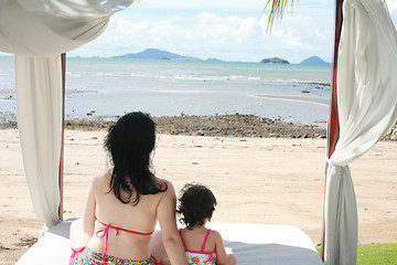 Image showing young lovely mother and her little daughter on tropical white be