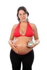 Image showing young pregnant woman holding house model over white background 