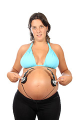 Image showing beautiful pregnant woman with headphones in belly