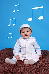 Image showing Portrait of a happy baby boy Isolated on blue background listen 