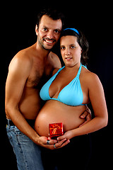 Image showing beautiful and happy & young pregnant couple holding present