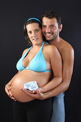 Image showing beautiful and happy & young pregnant couple with baby socks