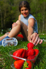 Image showing Young woman grabbing for fresh strawberry