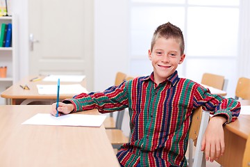 Image showing Confident boy sitting alone in classroom