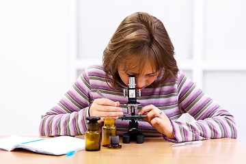 Image showing Schoolgirl looking into microscope