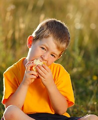 Image showing Boy eating apple