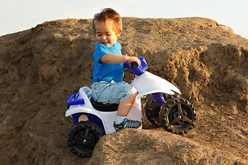 Image showing Boy driving toy quad on terrain