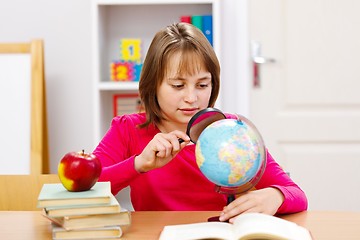 Image showing Schoolgirl searching with magnifier 