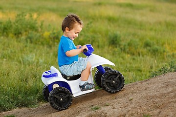 Image showing Little boy driving off road toy quad