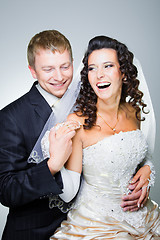 Image showing Laughing groom and bride on grey