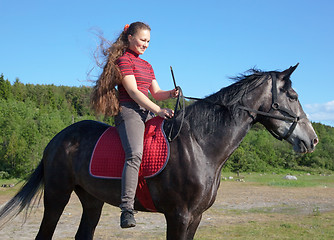 Image showing A girl with long hair on a horse
